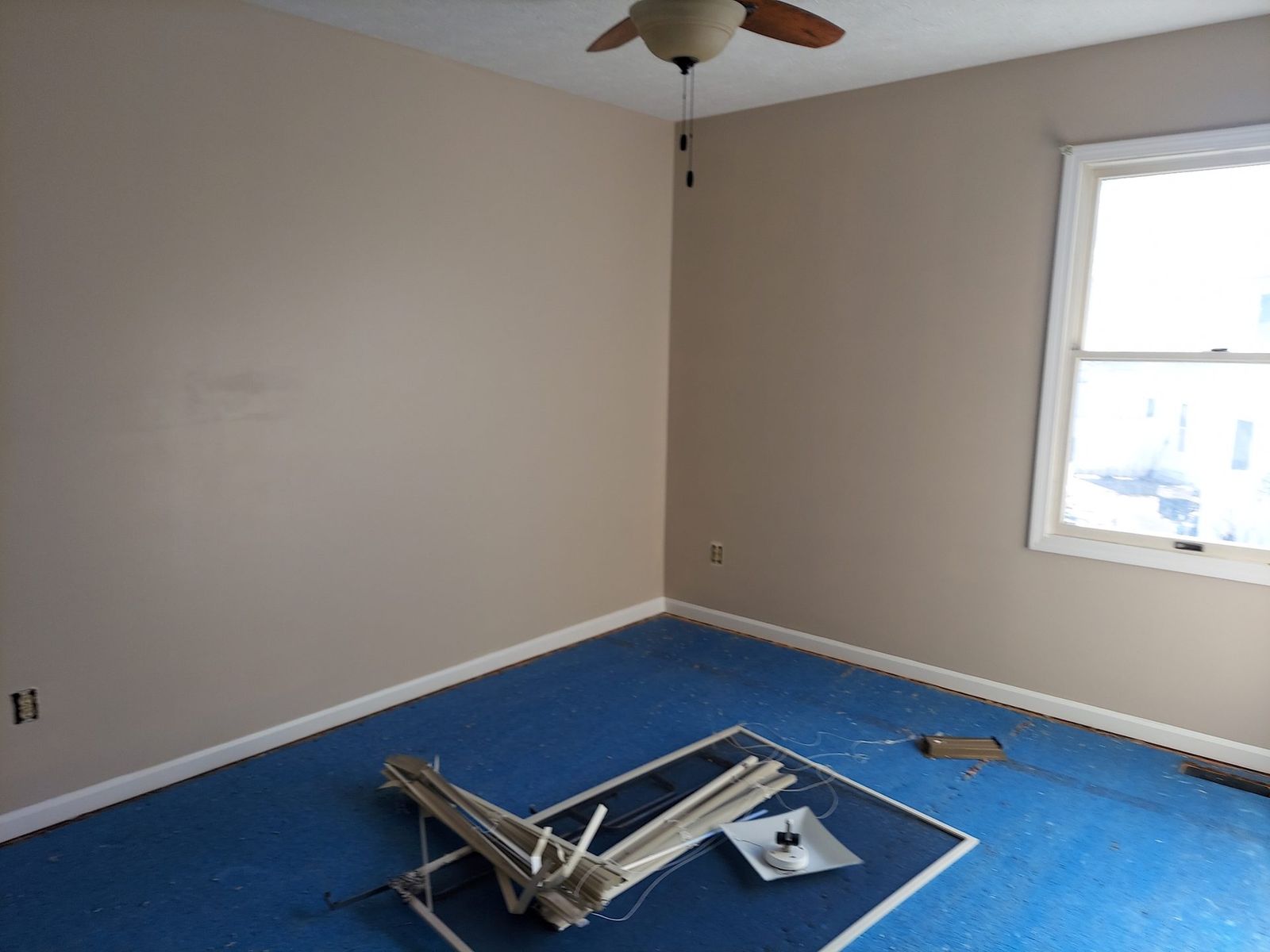 Freshly repainted apartment bedroom with floors protected during a unit turn