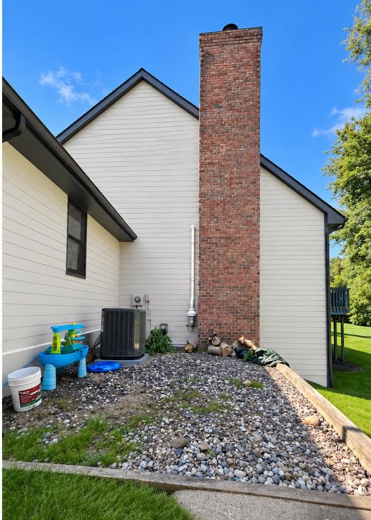 Finished exterior repaint — gray siding and brick chimney finished in white