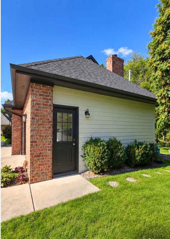 Completed exterior repaint — weathered gray siding refinished in a clean cream finish