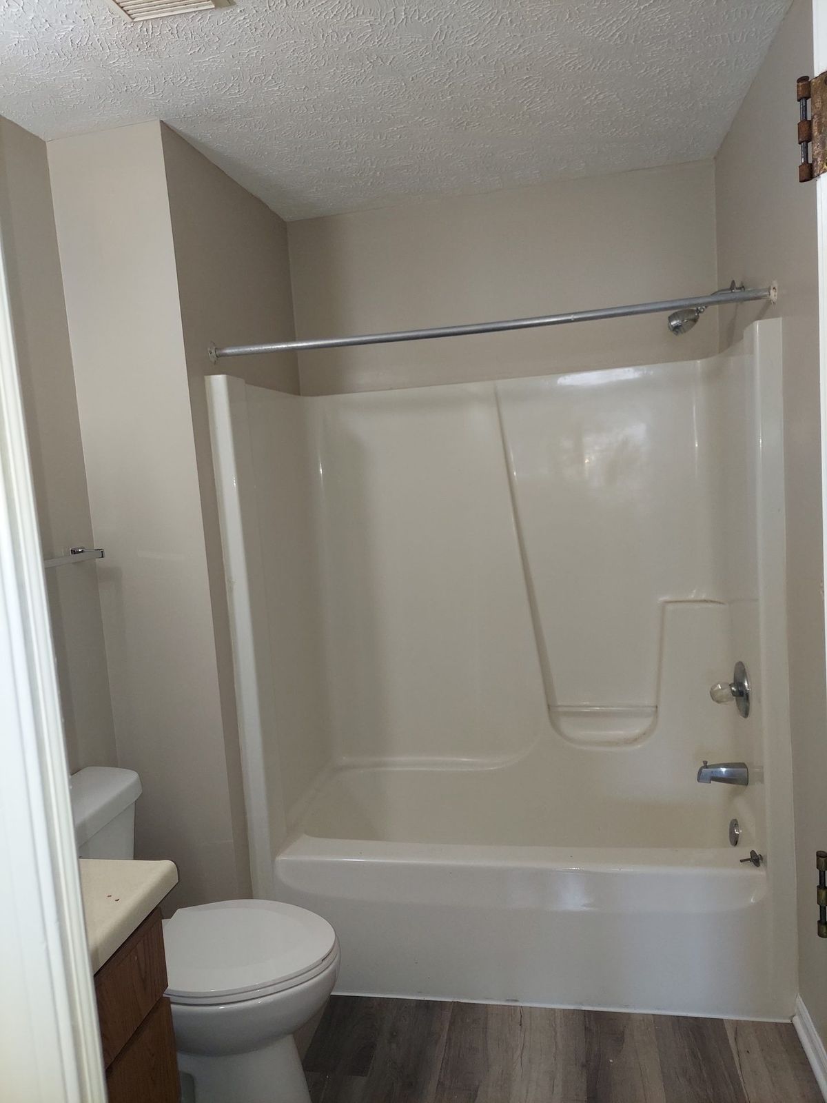 Finished bathroom with clean neutral walls and white shower surround