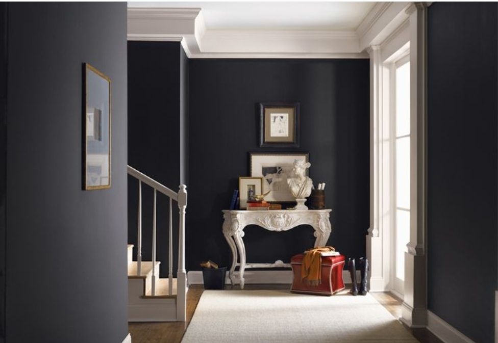 Finished foyer with deep navy walls — drywall repairs disappear under the final coat