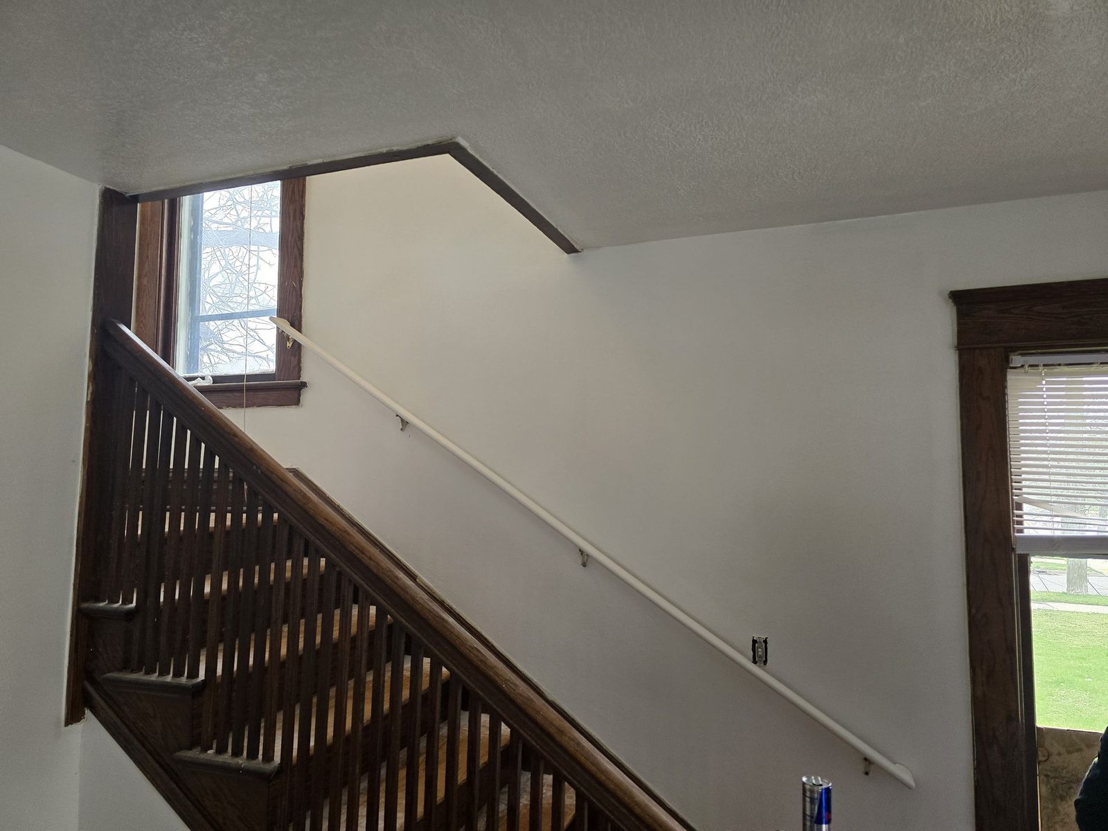 Fresh interior paint along a stairwell with dark wood trim