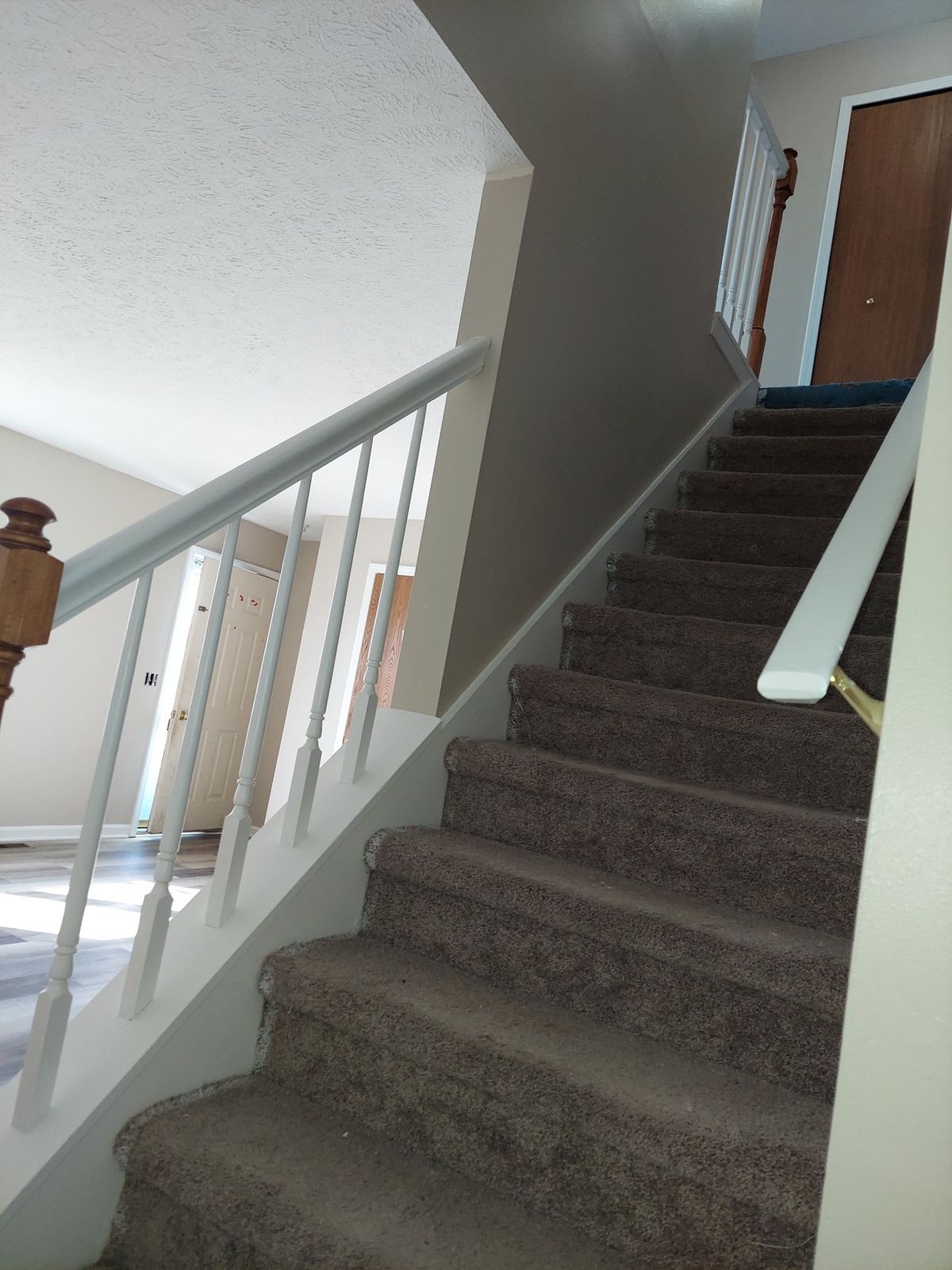 Finished stairwell with freshly painted white railings and carpeted stairs