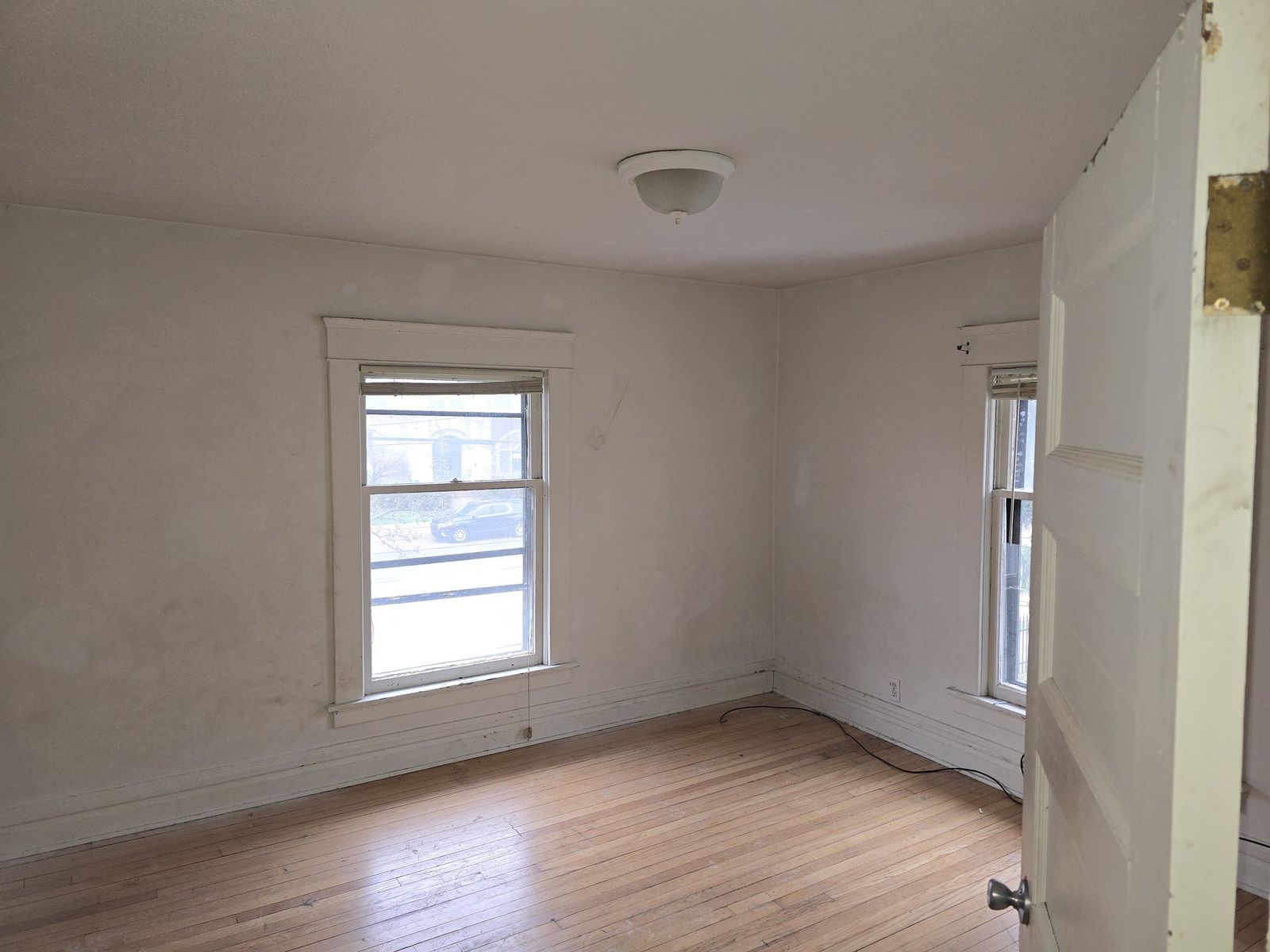 Repainted vacant room with wood floors