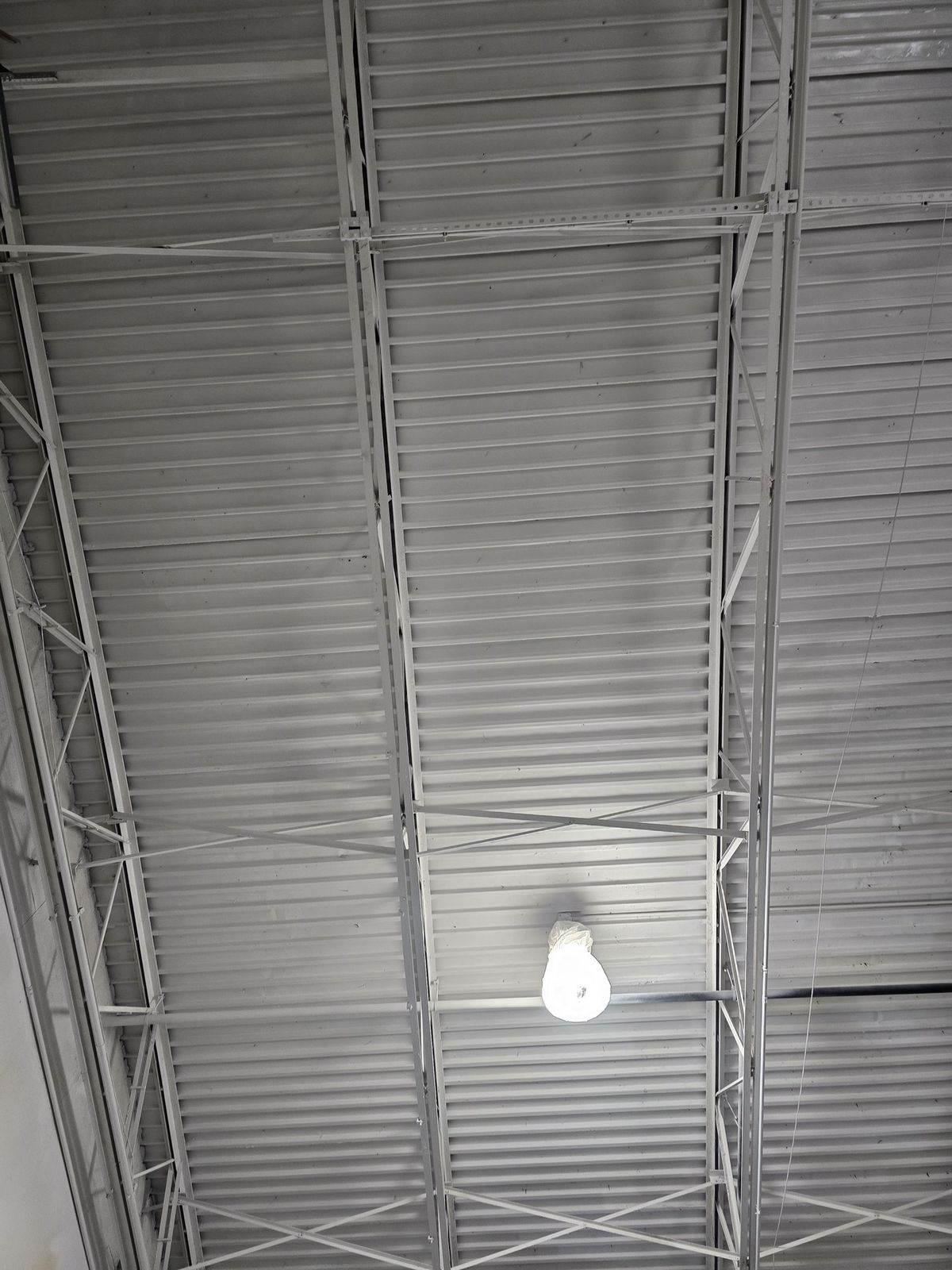 Overhead deck and trusses coated white in a commercial warehouse