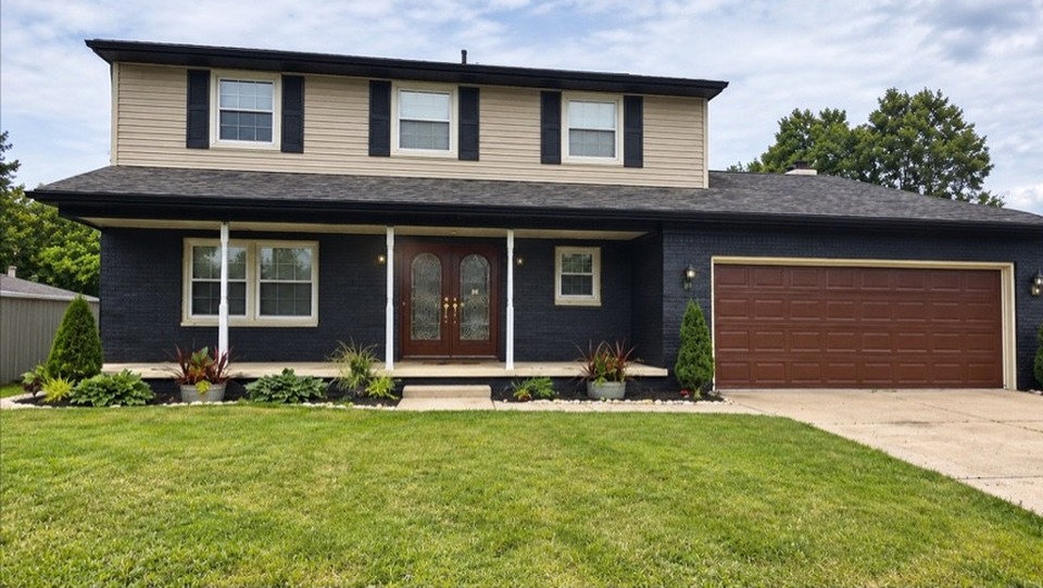 Two-story Waverly area home after the brick was painted black with Sherwin-Williams Loxon and the garage door refinished in brown
